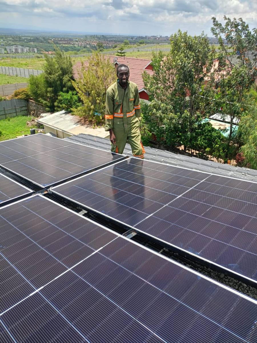 Technician on a rooftop solar installation in Pridelands